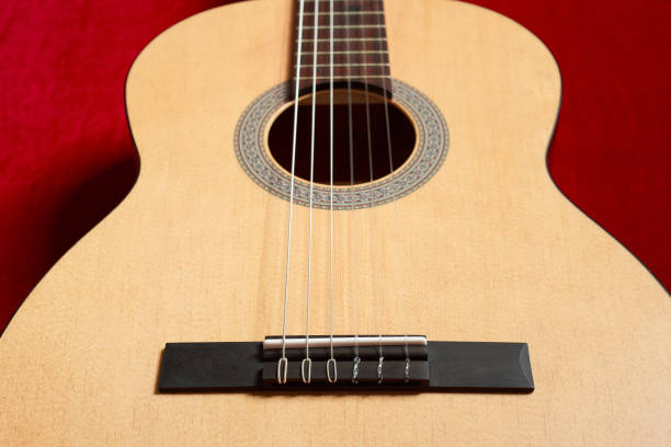 istock acoustic guitar on red velvet fabric, closeup object 847909858