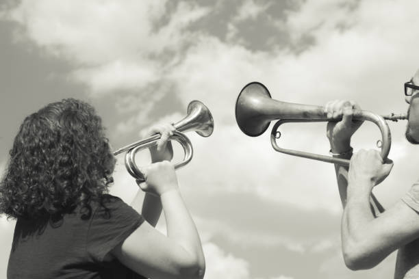 istock Man and woman playing trumpet on sky background 847912768