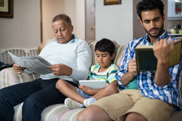 istock Boy with grandfather and father sitting on sofa 847912962