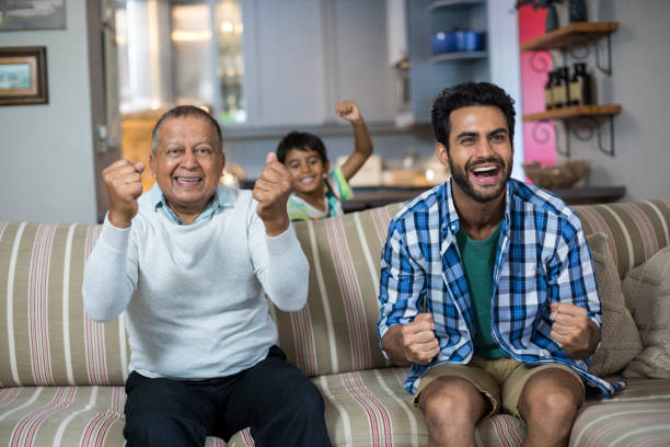 istock Family clenching fist while watching soccer match 847913064