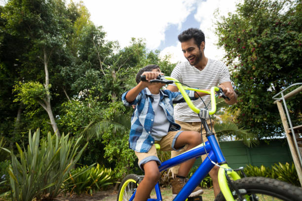 istock Happy father assisting son for cycling 847915640