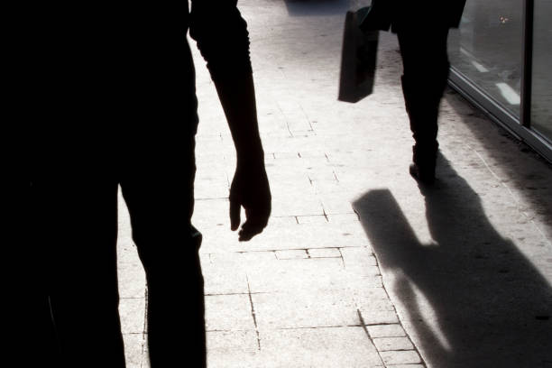 blurry silhouette and shadows of two person walking - crime scene investigation imagens e fotografias de stock