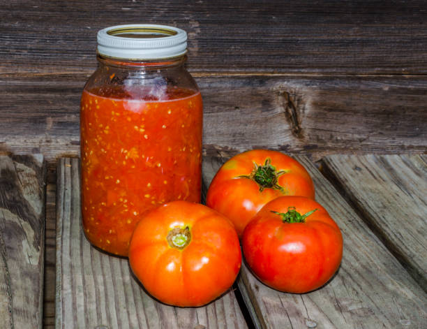 Home canned tomatoes with fresh whole tomatoes stock photo
