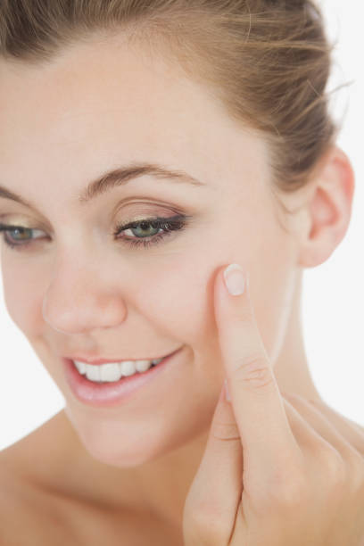 istock Happy woman applying cream on cheek 847955676