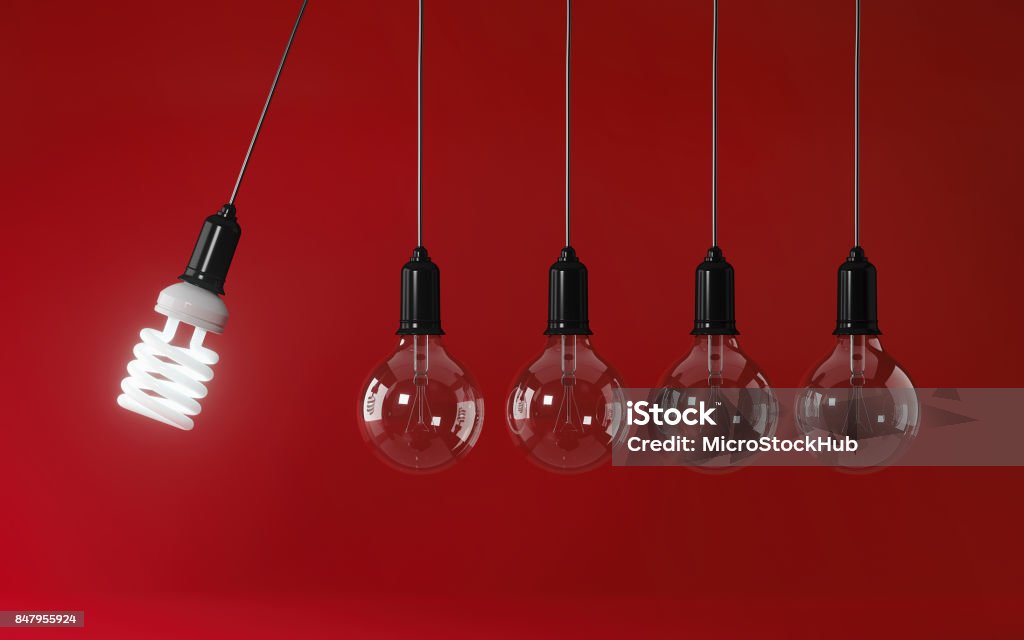 Ampoule économie d’énergie lumière en perpétuel mouvement sur fond rouge : Concept d’efficacité énergétique - Photo de Impact libre de droits