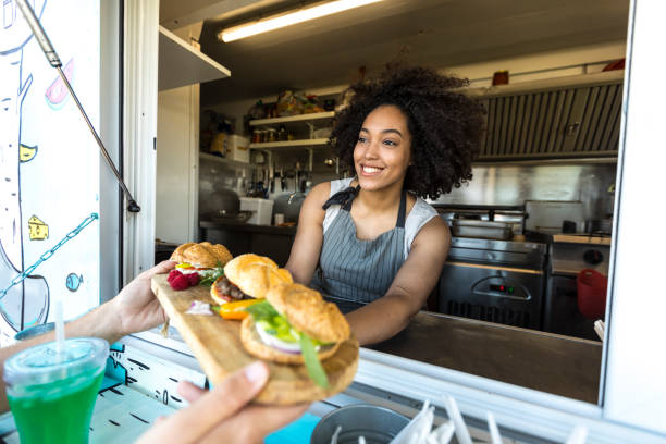 istock Female food van worker giving order to customer 847956492