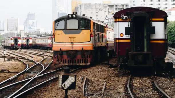 Photo of Railway train on the railroad tracks in Bangkok station. Many people in Thailand popular travel by train because it is cheaper.