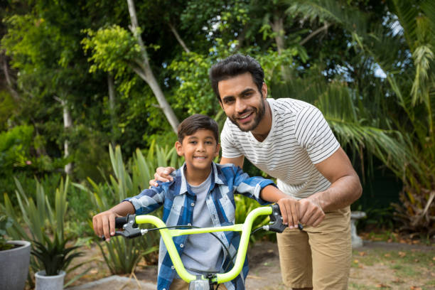 istock Portrait of father with son sitting on bicycle 847962952