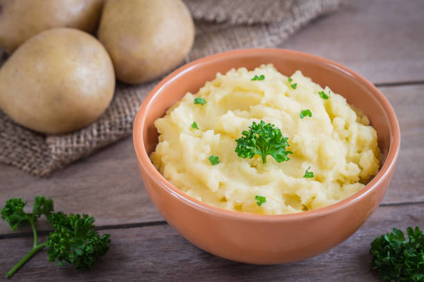 istock Mashed potato in bowl and fresh potatoes on sackcloth 847967446