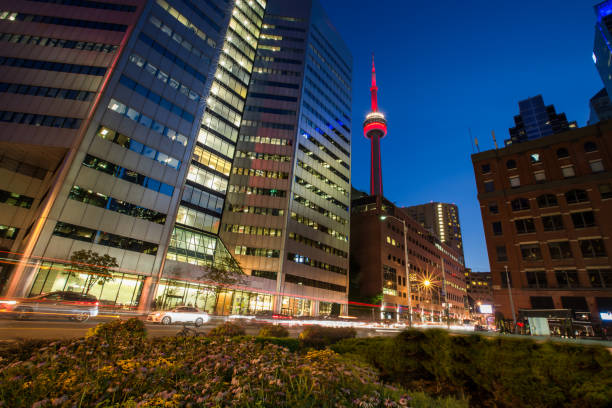 Aerial view of Toronto skyline featuring the CN Tower during a vibrant sunset, showcasing modern skyscrapers and urban landscape.