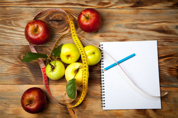 istock Apples, a diet plan and a centimeter on a wooden background 848004920