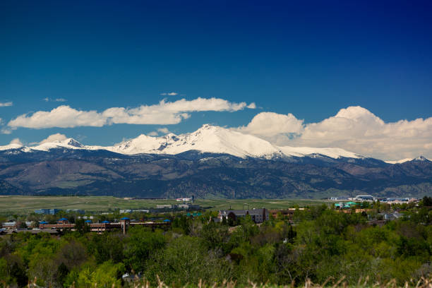 Longs Peak Spring Clouds Wide Wide shot of several front range cities, Rocky Mountain Airport, the foothills above Boulder, and Longs Peak. front range mountain range stock pictures, royalty-free photos & images