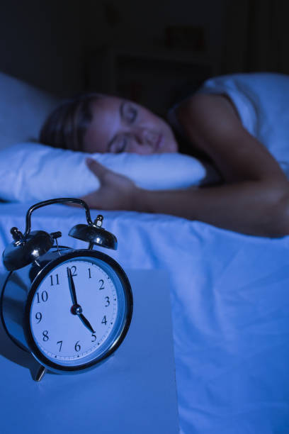 istock Alarm clock in front of a sleeping woman 848020634