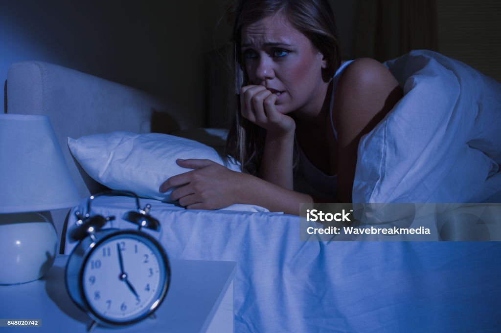 Unquiet blond woman in the bed at night Unquiet blond woman in the bed at night in the bedroom 20-24 Years Stock Photo