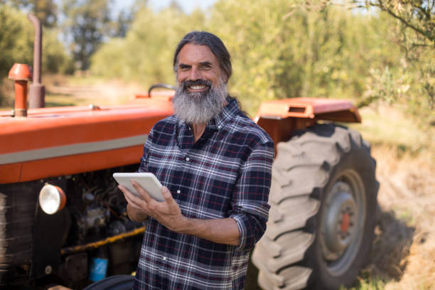 istock Portrait of happy man using digital tablet in olive farm 848021240