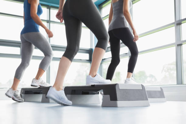 three women doing aerobics - the next step imagens e fotografias de stock