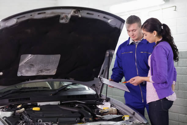 istock Mechanic standing with a clipboard next to a client 848023866