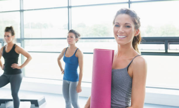 istock Woman holding a mat and two other women 848047564