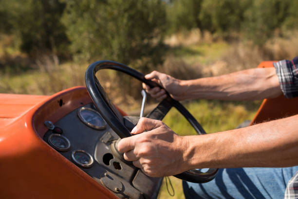 istock Mid section of man driving tractor in olive farm 848048162