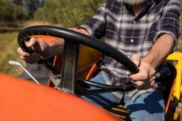 istock Mid section of man driving tractor in olive farm 848048204