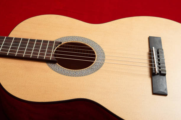 istock acoustic guitar on red velvet fabric, closeup object 848079082