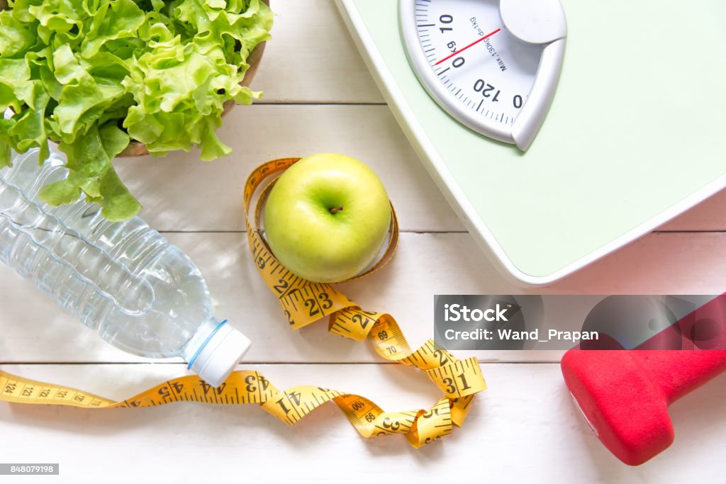 Verde manzana y escala de peso, toma de medida con vegetales frescos, agua potable y equipos de deporte para las mujeres la dieta adelgazante.  Dieta y el concepto saludable - Foto de stock de Régimen alimenticio libre de derechos