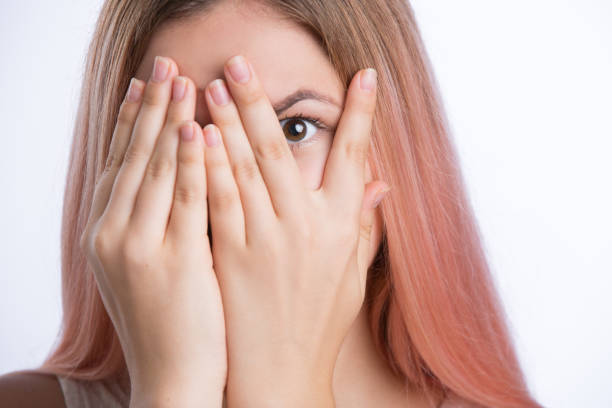 istock Young woman covers face with her hands and peep through her fingers 848079310
