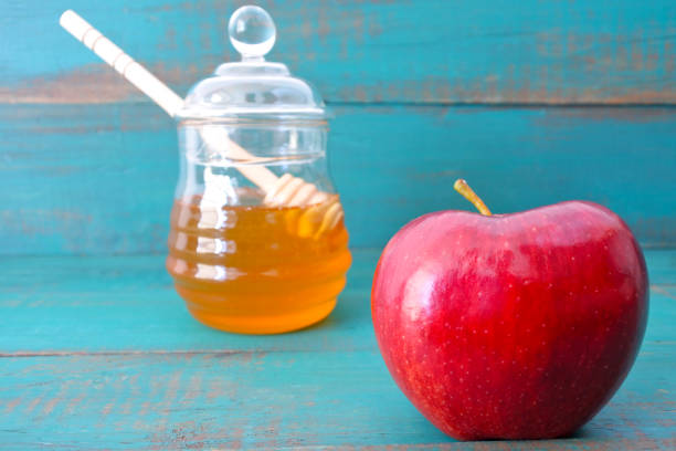 istock Red apple and honey jar on a turquoise background 848103970