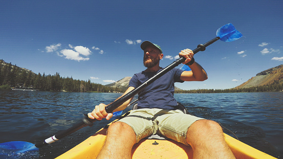 POV of a man kayaking in a calm lake