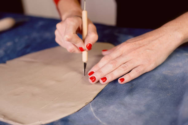 istock Creative workshop of ceramist. Trimming with a scalpel , creating the form an earthen dish.Workflow 848112268