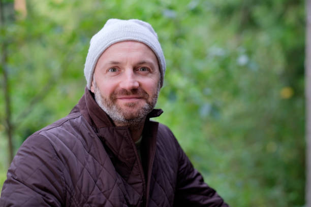 istock handsome mature man smiling in warm hat and jacket looking at camera 848135800