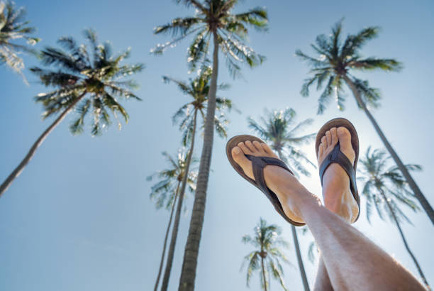 The lower part of men's feet in white socks and sandals