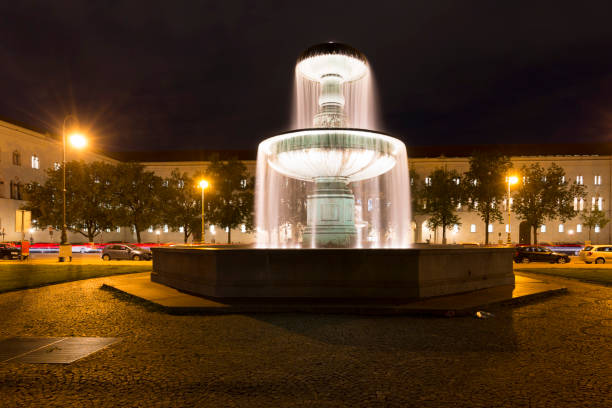 Munich, Germany - August 01, 2019:  Karlsplatz (Stachus), Munich, Bavaria, Germany, a bustling place with a fountain and historic buildings, like the Karlstor gothic gate.