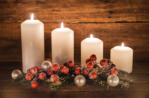 Arrangement for Advent with white Christmas candles and decoration.