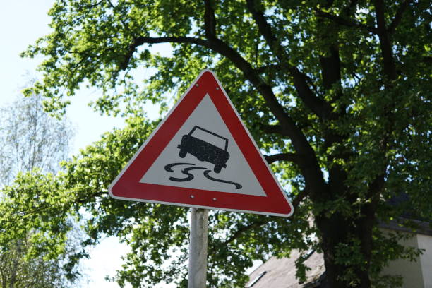 traffic sign for slippery road - skidding bend danger curve imagens e fotografias de stock