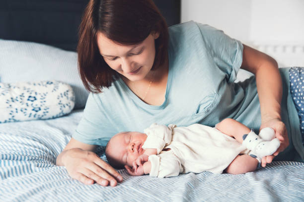 istock Young mother looking on her newborn baby. 848185562
