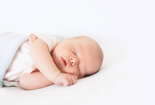 новорожденный ребенок спит первые дни жизни. - baby lying down indoors one person стоковые фото и изображения