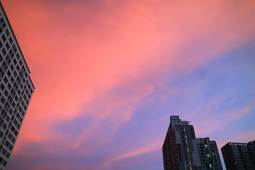 Stunning vibrant pink and blue clouds layer sunset sky over the high buildings in Bangkok's urban, Thailand