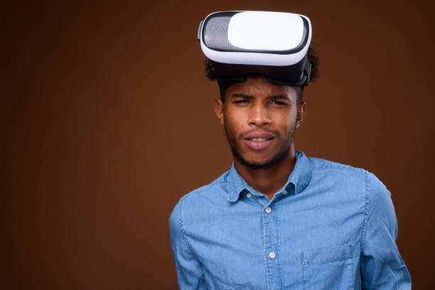 istock Studio shot of young handsome African man using virtual reality headset against colored background 848208720