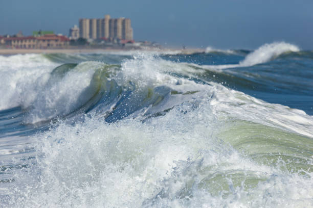 Waves crash near the shore in Deal, New Jersey. Long Branch is visible in the background.