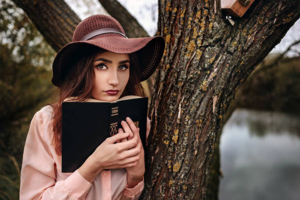istock Girl-student sit on lawn and reads textbook 848220098