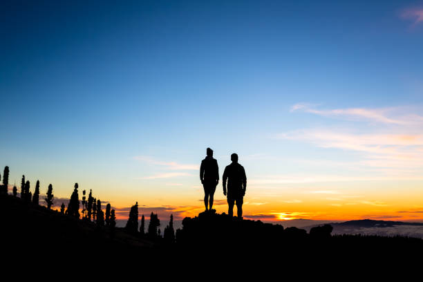 istock Teamwork couple climbing and reaching mountain peak 848226446