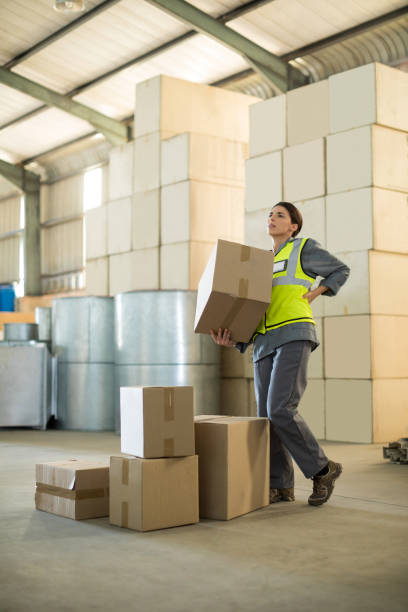 istock Female worker suffering from back pain while holding heavy box 848267252