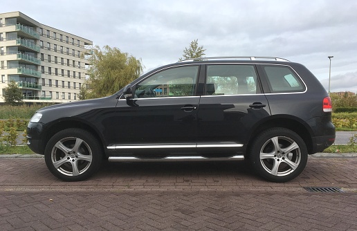 Almere Poort, Flevoland, The Netherlands - September 16, 2017: Black Volkswagen Tiguan parked on a public parking lot in the city of Almere. Nobody in the vehicle.