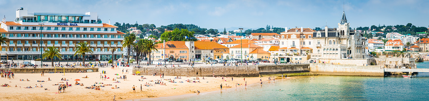 Sunbathers, tourists and holiday makers enjoying the sunshine and sandy beaches of Cascais, the picturesque seaside resort on the outskirts of Lisbon, Portugal.