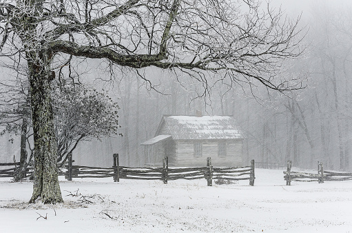 An isolated rustic cabin covered in fresh snow in The Cumberland Gap National and Historic park