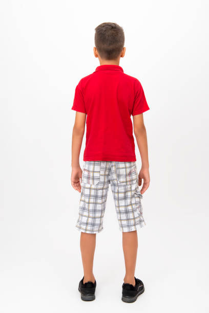 istock Rear view of little boy standing over white background - full length - 848284552