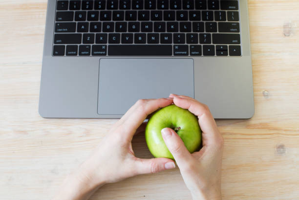 istock Hands holding green apple near laptop 848285196
