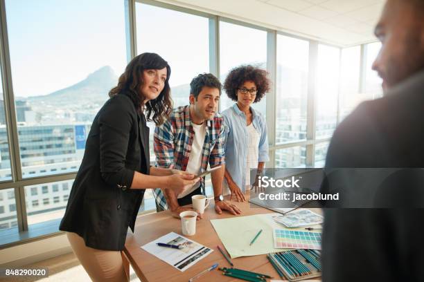 Team Brainstorming Over New Designs In Office Stock Photo - Download Image Now - Travel Agency, Advertisement, Technology