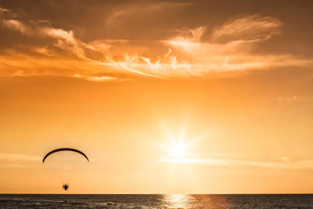 Photo of Paraglider flying at sunset